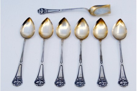 Conjunto de seis colheres de café e pá de açúcar em prata com relevos nos cabos em forma de folhas.